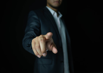Businessmen wear suits pointing to touch something Is an object for graphic lines, able to add anything. With a black background, business, or financial concept.