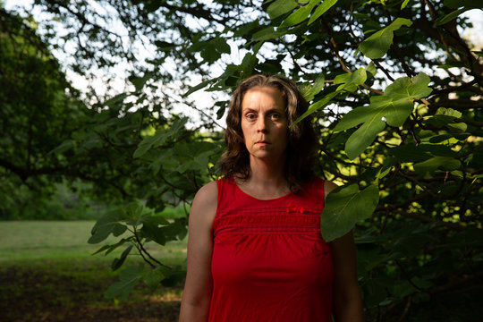 Woman in red slip by fig tree