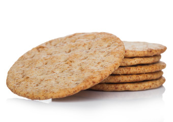 Stack of round organic crispy wheat  flatbread salty crackers on white.