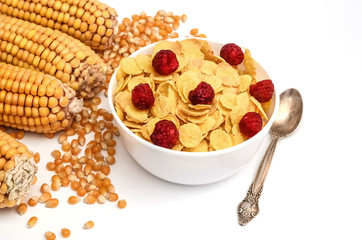 Cornflakes with raspberries and ears of corn close-up isolated on a white background. Healthy food, breakfast