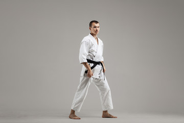 karate man standing against gray background © Nikola Spasenoski