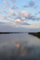 Wide river Danube with green coast. City in the distance