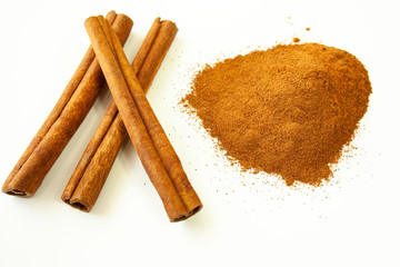  Cinnamon sticks and ground cinnamon on a white background