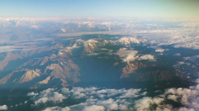 Himalayas high mountain range view in the window of an airliner at cruising altitude