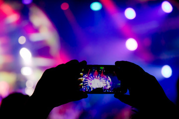 Silhouette of a person shooting the concert stage light with mobile phone - 343181062