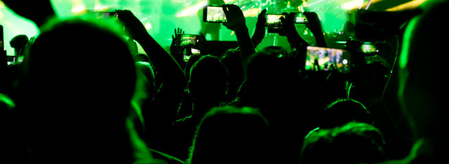 Silhouettes of a people hand shooting the concert with mobile phones - 343181065