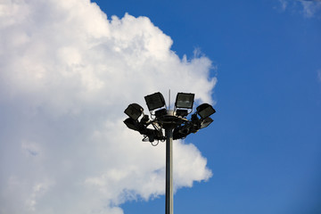 Street light pole with blue sky and white cloud backdrop