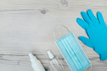 protective mask, gloves and antiseptics on a wooden background