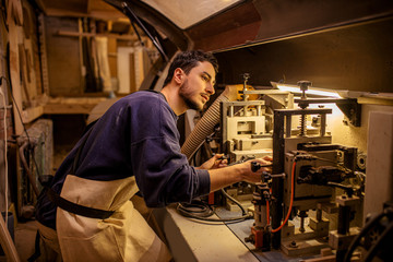 handcraft and woodworking concept. carpenter behind electric powerful machine in factory, make perfect wooden pieces