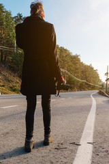 Obraz premium tourist near the road holding a reflex camera. vacation concept. vertical stock image.
