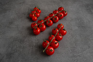 Cherry tomatoes on the vine on black stone background. Concept for healthy nutrition. Symbolic...
