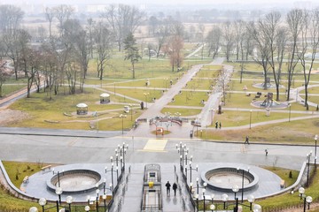 Beautiful modern park in the center of Mogilev.  Updated city park with stone stairs metal lanterns and park design. Top view. park area with a staircase and a fountain.
