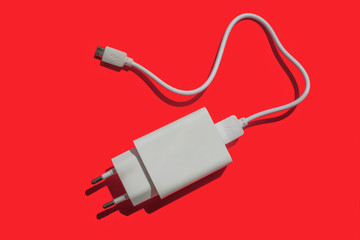Power supply with removable usb cable on a red background