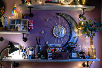 A shelf that is decorated with lots of vintage antiques and lots of cool fairy lights