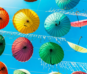 Multicolored umbrellas closeup on the blue sky background.