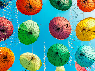 Multicolored umbrellas closeup on the blue sky background.