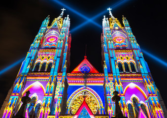 Fototapeta na wymiar The neo - gothic style Basilica of the National Vow (Basilica del Voto Nacional) illuminated with colorful lights during the Quito light festival.