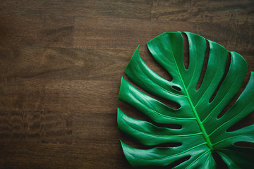 Monstera leaf top view philodendron leaf pattern on old wooden table background, copy space © Nabodin