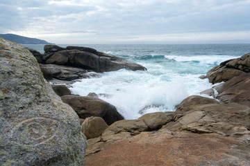 Fototapeta na wymiar Rock, ocean and waves. Blue colours
