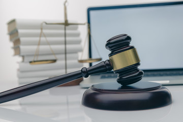 Workspace of lawyer with laptop blank white screen and law wooden gavel,legal book and brass scale...