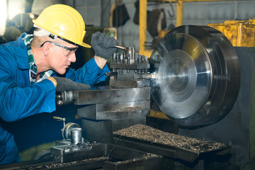 Engineers, experienced technicians Caucasian man are working by controlling steel lathes, turning...
