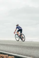 Foto op Aluminium Isolated female road cyclist cycling up the hill © Mikel Taboada