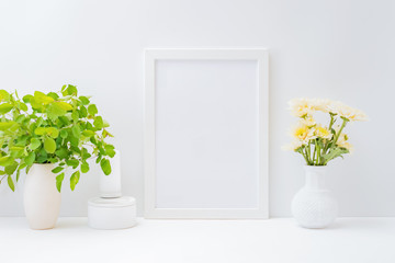 Home interior with decor elements. Mockup with a white frame and flowers in a vase on a light background