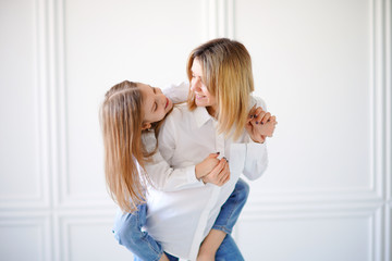 Fototapeta premium Portrait of little girl loving mother and holding her.