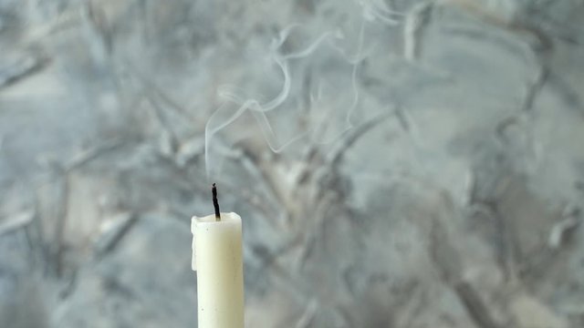 Smoke from an extinct candle on gray background. Concept of loss