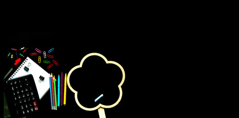 School stationery on black background. The concept of the teacher's day. Copy space