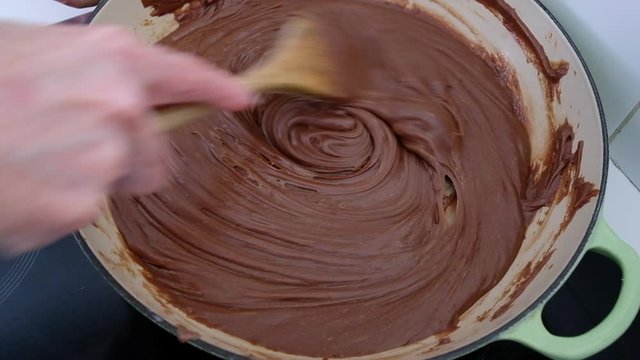 Home cook making chocolate fudge in a cast iron pan in a personal kitchen