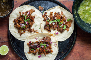 Carnitas tacos with red onion and raw green salsa