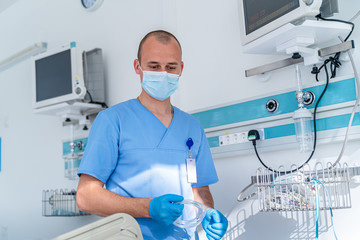 Doctor in mask. Special modern chamber in hospital. Modern medical bed and a special device in the...