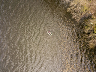Fishing inflatable boat on a forest lake. Aerial drone view.