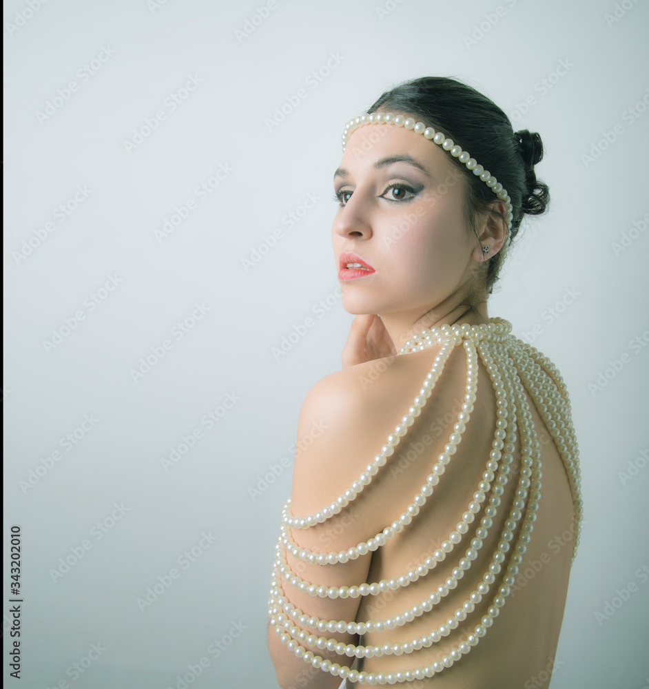 Wall mural model with gathered hair, dressed in pearls. with copyspace