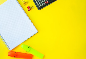 open notebook in a ruler on a yellow background. next to office supplies. business concept for a...