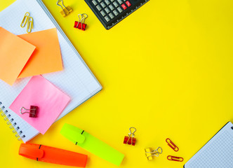 open notebook in a ruler on a yellow background. next to office supplies. business concept for a girl or back to school