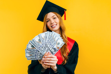 beautiful graduate girl, in a black gown, and a black master's hat, with dollars in her hands,...