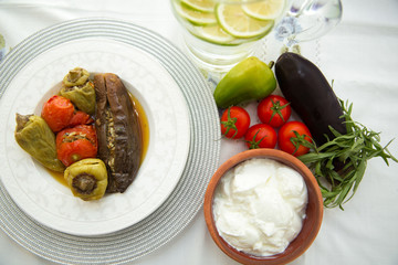 Eggplants are stuffed with meat lamb and rice. Patlican . eggplant filling . Eggplant, peppers, tomatoes . Yogurt in a brown bowl . Chopped lemon in a glass jar . Stuffed eggplant in the plate .