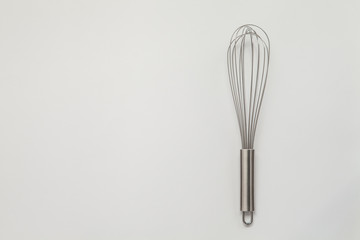 Metal whisk for whipping on a white background.