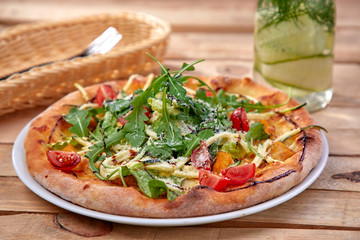 pizza with fresh vegetables on the wooden background