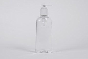 Plastic bottle with moisturizing or disinfecting liquid or gel, on white background. Cosmetics for care of skin of face and body. Sanitizer for cleaning house and removing dirt and germs from surfaces