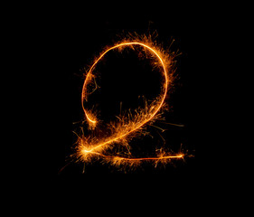 number two written with a sparkler on a black background