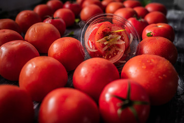 Ripe tomatoes on dark wooden background