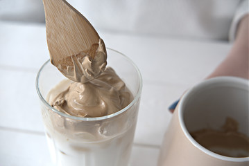 making dalgona coffee. Step 8, step by step visual instruction how to make korean trendy fluffy coffee drink. put coffee foam on cold milk. 