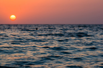 Obraz premium Amazing sea sunset on the pebble beach, the sun, waves, clouds