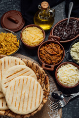 Top view of typical Latin American food. Group of arepas and different types of ingredients to fill them