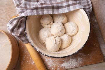 Balls of dough are in a large yellow bowl. Cooking at home.