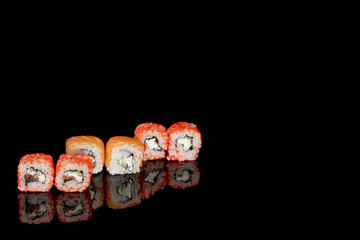 Philadelphia roll with salmon, cheese and cucumber on a black background with reflection. Sushi Philadelphia