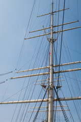 The empty masts of a three-masted sailing boat